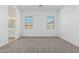 An inviting bedroom featuring neutral carpeting and two bright windows at 11950 W Parkway Ln, Avondale, AZ 85323