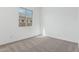 An inviting bedroom featuring neutral carpeting and a neighborhood view at 11950 W Parkway Ln, Avondale, AZ 85323