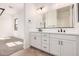 A bright bathroom features a double vanity with white cabinets and modern hardware at 12007 W Parkway Ln, Avondale, AZ 85323