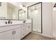 A bright bathroom with double vanity, modern hardware, a framed mirror, and glass shower at 12007 W Parkway Ln, Avondale, AZ 85323