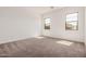 A bright bedroom features two windows and soft carpet at 12007 W Parkway Ln, Avondale, AZ 85323