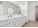 Bright bathroom featuring a double vanity with white cabinets and a large mirror at 12012 W Parkway Ln, Avondale, AZ 85323