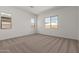 A clean and bright bedroom with multiple windows allowing natural light and plush carpeting at 12012 W Parkway Ln, Avondale, AZ 85323