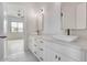 Bright bathroom featuring double sinks, marble countertops, and modern fixtures with access to another room at 32278 N 168Th Ave, Surprise, AZ 85387
