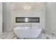 Luxurious bathroom with freestanding tub, fireplace, marble flooring and elegant chandelier at 32278 N 168Th Ave, Surprise, AZ 85387