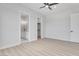 Spacious bedroom with neutral walls, laminate flooring, ceiling fan, and access to a walk-in closet and bathroom at 32278 N 168Th Ave, Surprise, AZ 85387