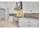 Detailed view of the kitchen showcasing a range with gold backsplash and ample white cabinets at 32278 N 168Th Ave, Surprise, AZ 85387