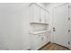 Laundry room with white cabinets and built-in shelving at 22886 E Alyssa Rd, Queen Creek, AZ 85142