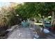 Relaxing back patio featuring a shaded seating area with lush greenery and a tiled surface at 6313 W Onyx Ave, Glendale, AZ 85302