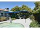 Backyard patio with a shade structure, lush landscaping and furniture at 6313 W Onyx Ave, Glendale, AZ 85302