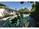 Backyard swimming pool surrounded by lush landscaping and a patio area at 6313 W Onyx Ave, Glendale, AZ 85302