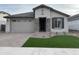 Single-story home with gray exterior, stone accents, and a landscaped front yard at 9987 W Verde Ln, Avondale, AZ 85392