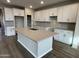 Spacious kitchen with white cabinets, herringbone backsplash, and large island at 9987 W Verde Ln, Avondale, AZ 85392