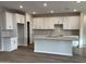 Modern kitchen featuring white cabinets, a large island, and herringbone backsplash at 9987 W Verde Ln, Avondale, AZ 85392