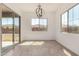 Bright dining room featuring tile floors, a stylish light fixture, and sliding glass doors to backyard at 12015 W Parkway Ln, Avondale, AZ 85323