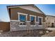 Exterior view showcasing stone accents and desert landscaping enhancing the home's curb appeal at 12015 W Parkway Ln, Avondale, AZ 85323