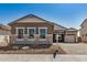 Charming single-story home featuring a stone facade, well-maintained landscaping, and a cozy, inviting entrance at 12015 W Parkway Ln, Avondale, AZ 85323