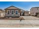 Exterior of a home featuring a three car garage, desert landscaping, and stone accents at 12015 W Parkway Ln, Avondale, AZ 85323