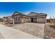 Charming home exterior featuring a three car garage, stone accents, and a paved driveway at 12015 W Parkway Ln, Avondale, AZ 85323