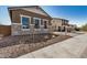 Exterior view of the home with stone accents, desert landscaping and lush green backyard at 12015 W Parkway Ln, Avondale, AZ 85323