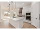 Open-concept kitchen boasting an island, stainless steel appliances, pendant lighting, and seamless access to the living area at 12015 W Parkway Ln, Avondale, AZ 85323