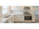 Another view of the updated kitchen, showing stainless steel sink, gas range and quartz countertops at 18009 N 15Th Dr, Phoenix, AZ 85023