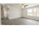 Bright living room with wood-look tile flooring, ceiling fan and a front door letting in natural light at 18009 N 15Th Dr, Phoenix, AZ 85023