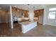 Modern kitchen boasts granite countertops, stainless steel appliances, and stylish pendant lighting over the island at 21369 W Hillcrest Blvd, Buckeye, AZ 85396