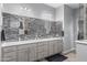 Bathroom with dual sinks, mosaic backsplash, and bright vanity lighting at 12204 W Blackhawk Rd, Casa Grande, AZ 85194