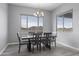 Dining room with a dark wood table, seating for six, modern light fixture, and large windows at 12204 W Blackhawk Rd, Casa Grande, AZ 85194