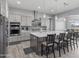 Modern kitchen with stainless steel appliances, large island with seating, and gray shaker cabinets at 12204 W Blackhawk Rd, Casa Grande, AZ 85194