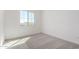 Bright bedroom featuring neutral walls and carpet, and a window bringing in natural light at 18002 W Vogel Ave, Goodyear, AZ 85338