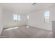 Bright bedroom with neutral carpet, white walls, and three windows at 18002 W Vogel Ave, Goodyear, AZ 85338
