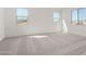 Bright bedroom with neutral carpet and two windows at 18002 W Vogel Ave, Goodyear, AZ 85338