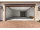 Spacious two car garage featuring a brick floor, white walls, and an automatic door opener at 18002 W Vogel Ave, Goodyear, AZ 85338