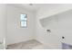 Functional laundry room featuring tile flooring and a bright window at 18002 W Vogel Ave, Goodyear, AZ 85338
