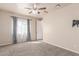 Carpeted bedroom featuring a ceiling fan and a window with curtains at 707 W Coles Rd, Phoenix, AZ 85041