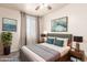 Comfortable bedroom with a ceiling fan, a queen-sized bed, bedside lamps, and complementing decorations at 707 W Coles Rd, Phoenix, AZ 85041