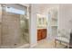 Bathroom featuring tiled shower and vanity area with wood cabinets at 26747 N 127Th Dr, Peoria, AZ 85383