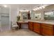 Bathroom featuring dual vanity, tiled counters, and decorative chair at 26747 N 127Th Dr, Peoria, AZ 85383
