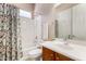 Bathroom with tub-shower combo and vanity, featuring a decorative shower curtain and mirror at 26747 N 127Th Dr, Peoria, AZ 85383