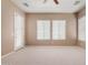 Large bedroom featuring neutral carpeting, ceiling fan, and several large windows at 26747 N 127Th Dr, Peoria, AZ 85383