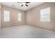 Bedroom features carpet flooring, ceiling fan, and multiple windows with blinds at 26747 N 127Th Dr, Peoria, AZ 85383