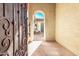 Inviting entryway with an arched opening and wrought iron gate for added security at 26747 N 127Th Dr, Peoria, AZ 85383