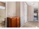 Hallway with tile flooring leading to a bathroom, showcasing a storage cabinet at 26747 N 127Th Dr, Peoria, AZ 85383