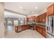 Open kitchen featuring stainless appliances, granite counters, and beautiful wood cabinetry at 26747 N 127Th Dr, Peoria, AZ 85383