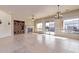 Open-concept living room with a ceiling fan, tile flooring, and large windows for natural light at 26747 N 127Th Dr, Peoria, AZ 85383