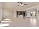 Large living room with tile flooring, chandelier, ceiling fan, and open layout to adjacent areas at 26747 N 127Th Dr, Peoria, AZ 85383