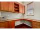 Office featuring custom wood cabinets, a built-in desk, and a window providing natural light at 26747 N 127Th Dr, Peoria, AZ 85383