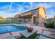 Fenced backyard featuring a pool and outdoor living space with a covered patio and pavers at 14244 W Indianola Ave, Goodyear, AZ 85395